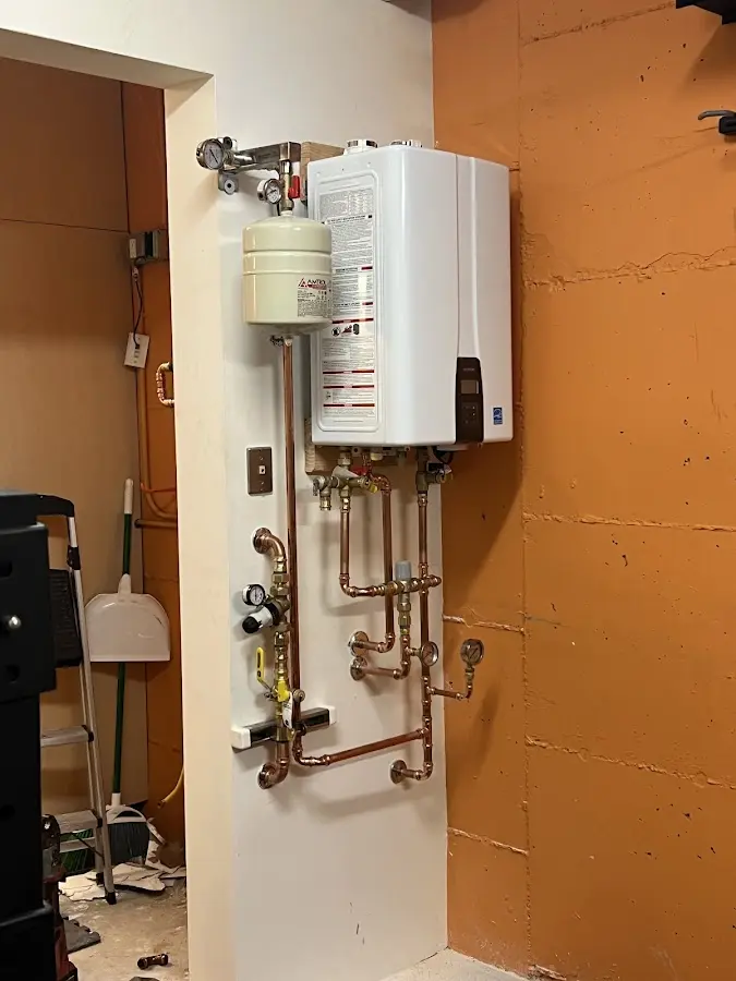 Plumbing technician inspecting water heater connections in Bellmawr